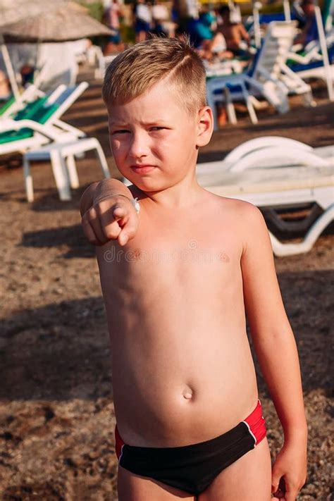 Il Ragazzo Di Sette Anni Serio Abbronzato In Spiaggia Bianca Mette Con Una Palla Su Una Corte Di