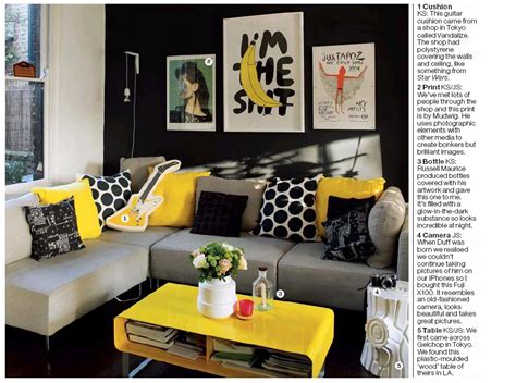 A boho living room with graphite grey walls, a grey sectional, grey, white and yellow bedding, a wooden table and potted plants. those pillows are awesome! | Yellow decor living room, Grey and yellow living room, Summer ...