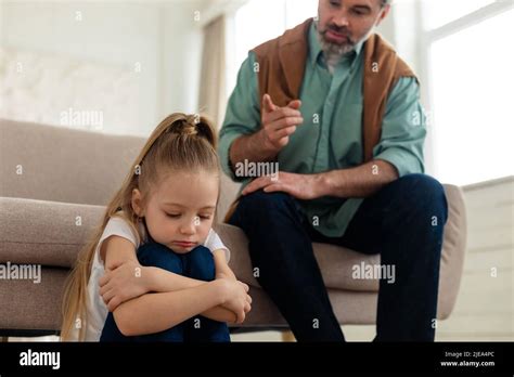 Strict Middle Aged Dad Scolding Depresssed Little Daughter At Home