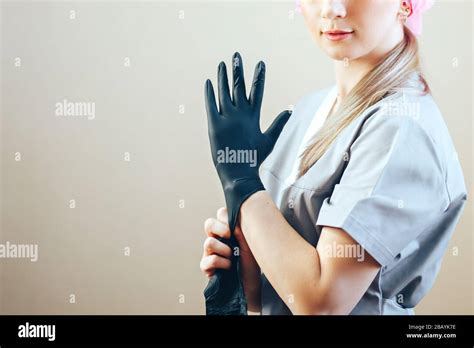 Beautician Woman Putting On Black Rubber Gloves She In Grey Blue
