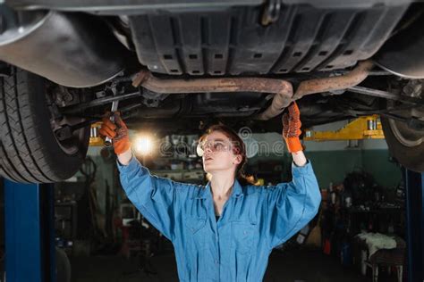 Female Auto Mechanic Working Under A Car In A Garage Portrait Of A