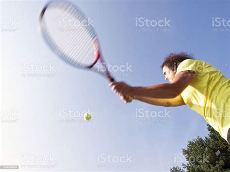 Woman Hitting Tennis Ball With Racquet Bright Sun Flared Side Stock