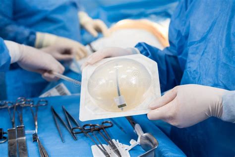 Surgeon In Operation Room Is Holding Sterile Breast Silicone Implant In