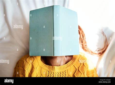 Shot Of An Unrecognizable Woman Lying With A Book Over Her Face Stock