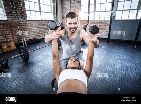 Personal Trainer Working With Client Holding Dumbbell Stock Photo Alamy