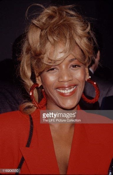 An Image Of A Woman Smiling At The Camera With Big Hoop Earrings On Her Ear