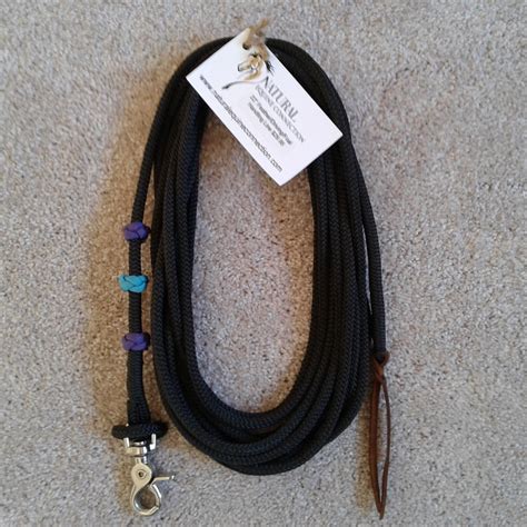 A Black Rope With Two Charms On It And A Tag Hanging From The End That