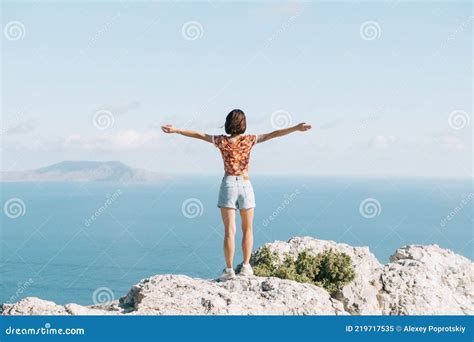 Woman Standing With Raised Arms On The Edge Of A Cliff Stock Image Image Of Excited Blue