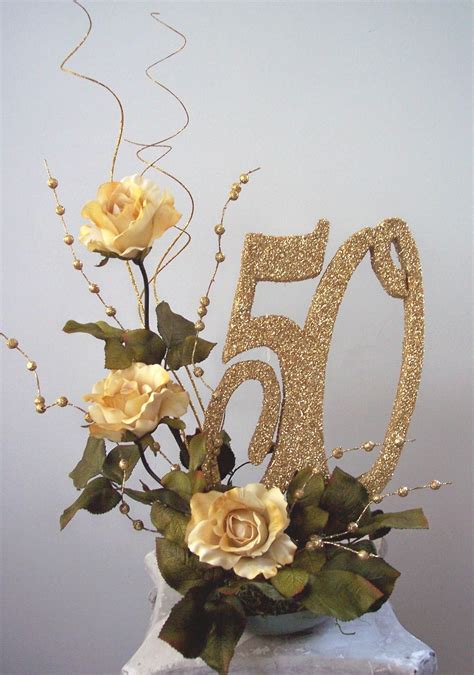 A 50th Birthday Cake Decorated With Flowers And Gold Glitter Number 50