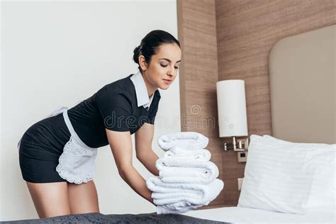 Maid In White Gloves Sitting On Bed And Touching Forehead With Closed Eyes Stock Image Image