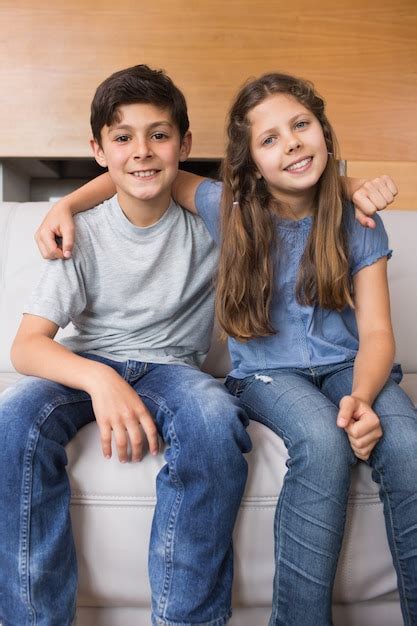 Premium Photo Portrait Of Smiling Little Siblings Sitting In Living Room