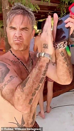 Robbie Williams Dances To Classic Abba Tune In His Swimming Trunks As He Enjoys Ibiza Daily