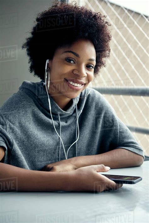 Young Woman Using Listening To Earphones Portrait Stock Photo Dissolve