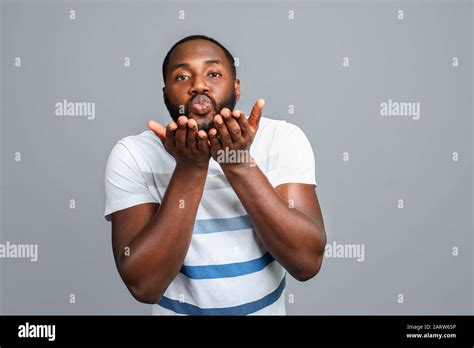 Handsome African American Man Blowing Kiss On Grey Background Stock