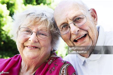 Happy Affectionate Old Couple Smile At Camera High Res Stock Photo
