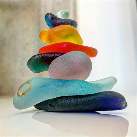 A Stack Of Colorful Rocks Sitting On Top Of A White Table