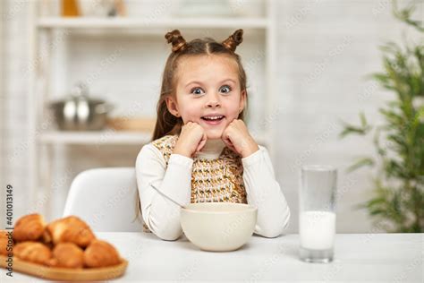 Adorable Little Girl Eating Breakfast Cereal With The Milk And