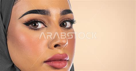 بورتريه لوجه مرأة عربية خليجية سعودية محجبة لإعلان تجاري ، خلفية ملونة ، صورة مقربة لمرأة عربية