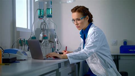 Scientist Find A Cure Woman Scientist Looking At Chemical Liquid In