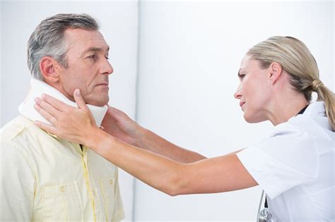 Doctor Examining Patient Wearing Neck Brace Stock Photo Download