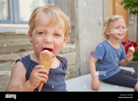 Two Boys Sitting Outside Eating Icecream Stock Photo Alamy