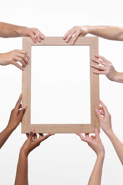 Free Photo Many Hands Holding Wooden Frame Front View