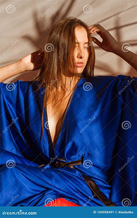 Beautiful Girl In Blue Silk Robe Resting In The Sunlight Stock Image