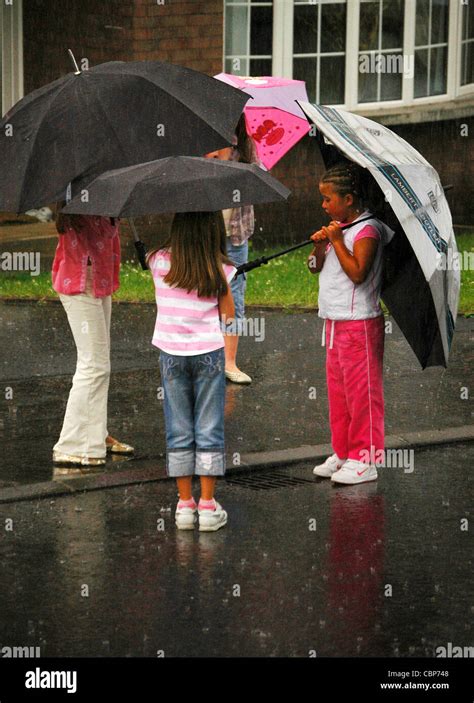 Young Girls Holding Umbrellas In Rain Hi Res Stock Photography And