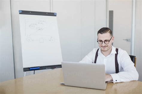 Businessman Using Laptop In Conference Room In Office Stock Photo