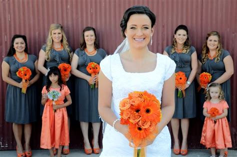 A Bride And Her Bridal Party In Front Of A Corrugated Wall With Orange
