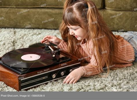 Cute Little Girl Listening To Music Through Record Player At Home