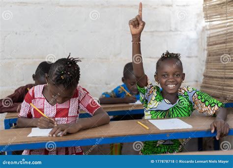 African School Children Raising Their Hands During Lesson Stock Photo