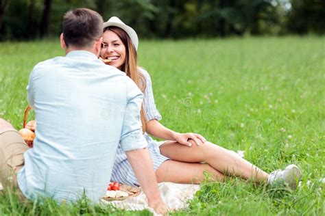 Happy Young Couple Having A Great Time In A Park Sitting On A Picnic
