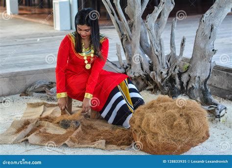 Beautiful Maldivian Woman In National Dress Smiling While Crafting