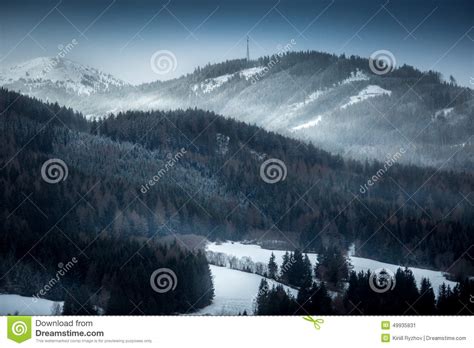Landscape Of High Mountains Covered With Snowy Forest At Evening Stock