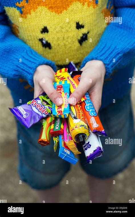 Boys Hands Holding Assorted Childrens Retro Sweets And Candy Stock