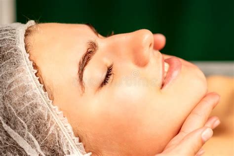Facial Massage Hands Of A Masseur Massaging Neck Of A Young Caucasian Woman In A Spa Salon The