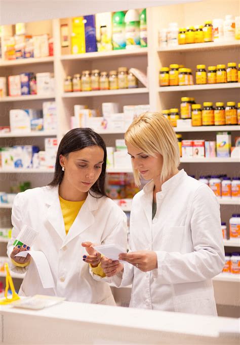 Female Pharmacists Working In A Pharmacy By Stocksy Contributor