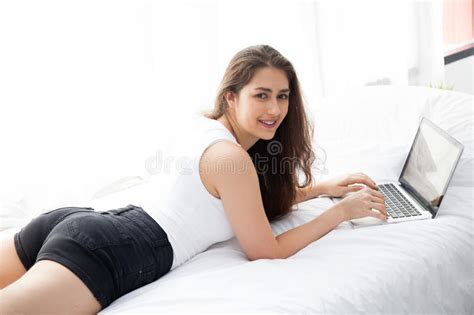 Beautiful Caucasian Woman Laying Down White Bed Using Laptop Stock
