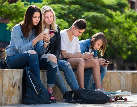 Positive Teenagers Playing With Mobile Phones Stock Photo Image Of