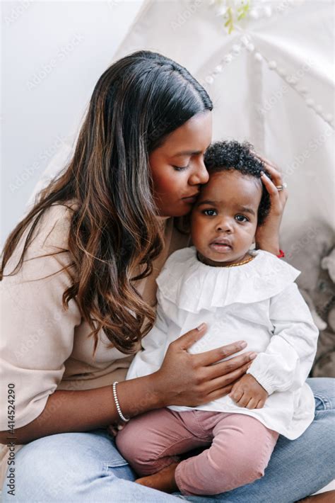 Happy Young Indian Mother Playing Kissing Mixed Race Black Baby Girl