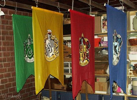 Three Harry Potter Flags Hanging From Hooks In Front Of A Brick Wall