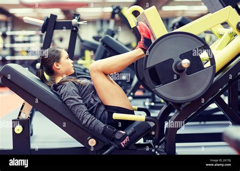 Woman Flexing Muscles On Leg Press Machine In Gym Stock Photo Alamy