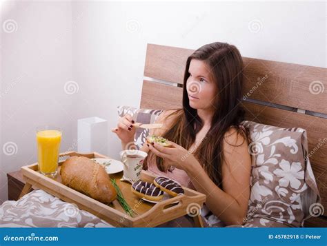 Beautiful Young Woman Eating Breakfast In Bed In The Morning Stock