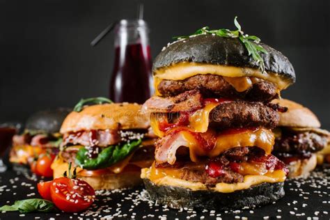 Many Different Burgers With Ingredients On A Black Background Stock