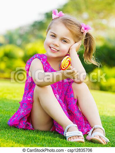 Little Girl With Lollipop Photo Of Cute Little Girl Sitting On Green