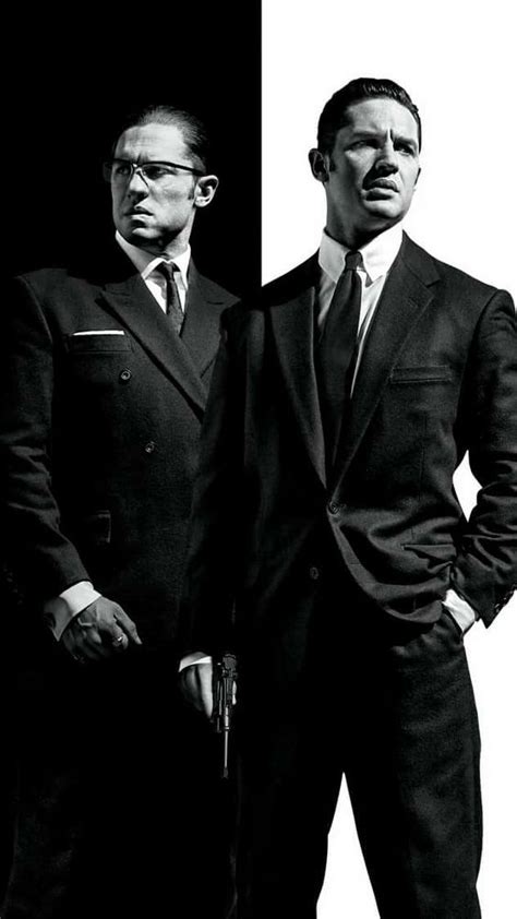 Two Men In Suits Standing Next To Each Other