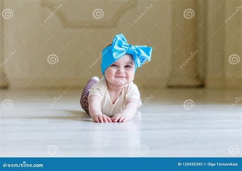 Cute Happy 6 Months Baby Girl With Bright Bow Crawling Indoor Pretty