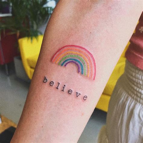 A Person With A Rainbow Tattoo On Their Arm That Says Believe And The