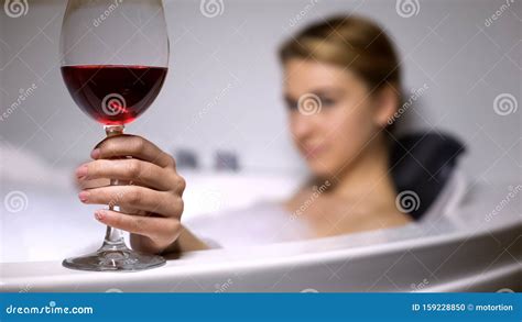 Donna Che Tiene In Mano Un Bicchiere Di Vino Rilassandosi In Una Vasca Da Bagno Accogliente Con